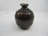 Front view of brown glazed Bizen Ware sake bottle