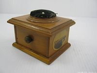 Three-quarter view showing box, knob, pincushion, transfer