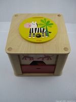 Top view showing yellow zebra lid and overall wooden cube