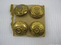 Front view of four brass buttons mounted on card