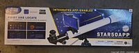 Front of sealed retail box showing STAR50APP 50 mm refractor telescope and included smartphone adapter
