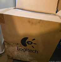 Outer shipping box with Logitech logo, visible water damage