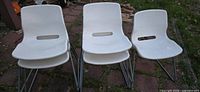 Front view showing three chairs including stacked units, white seats and grey sled legs