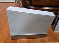 Left side view of white Wii console on stand