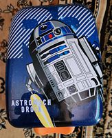 Front of blue R2-D2 hard-shell suitcase with ASTROMECH DROID text
