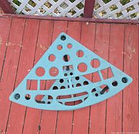Top view of teal triangular plastic shelf showing cut-out pattern