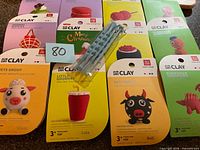 Group shot showing 12 sealed Air Dry Clay kits and three blue sculpting tools