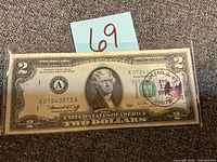Full view of $2 note in sleeve, showing serial number and postmark