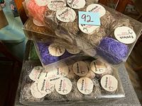 Stacked clear boxes showing Eyelash and Shadow yarn labels and colours