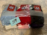 Factory-sealed bundle of nine pairs of children’s gloves showing assorted colours and mb55 labels