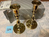 Two brass candlesticks beside Baldwin box