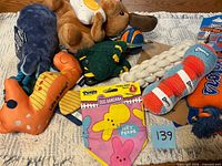 Group of all dog toys and bandana displayed on rug