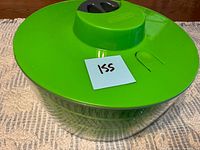 Salad spinner complete with green lid, grey handle, clear bowl
