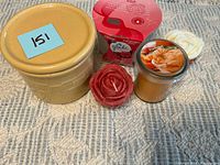 Group shot showing all items: pottery jar with lid, Glade candle package, red rose candle, orange jar candle, white rose candle