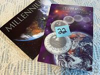 Front covers of Millennium coin booklet and display card