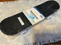 Full view of mini skateboard with label and wheels visible