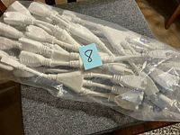 Bag containing multiple white power cord connector cables