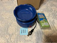 Warmer, wax melt pack, cord and plug on textured surface