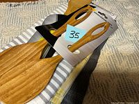 Kitchen towels stacked with packaged wooden spoons on top