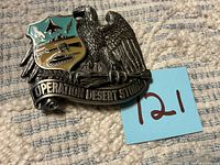 Front view of belt buckle showing eagle, shield and banner text