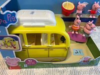 Front view of boxed yellow campervan with figures attached to side panel