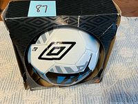 Soccer ball in damaged Umbro box front view