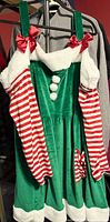 Front view of green velvet Christmas dress with striped sleeves and faux fur trim