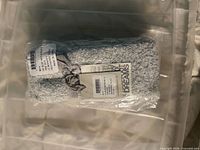 Grey fuzzy slipper socks rolled with label and ribbon inside clear bag