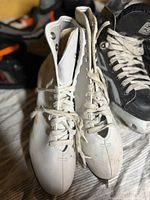 Top view of both white figure skates showing size, laces, blades, wear