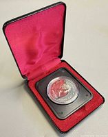 Coin in capsule inside open presentation case