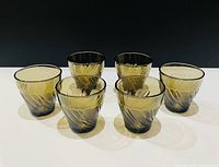 Front view of six amber swirl glasses