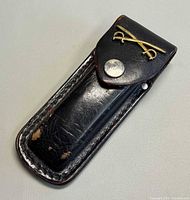 Front view showing brass crossed sabers insignia, snap and leather condition