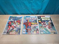 Front covers of Iron Man Annual #5, #7, #9 in bags and boards