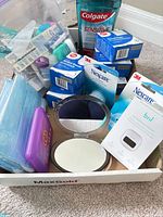 Overview of entire lot in box showing mouthwash, Nexcare boxes, Bril sterilizer, masks, compact mirror, travel case and gauze