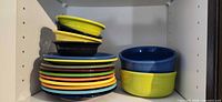 Stack of colorful Fiesta plates and bowls in cabinet