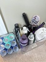 Overall view of bin with products, brushes, curlers and towel