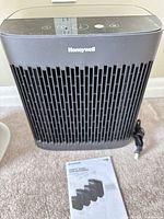 Front view of Honeywell HPA5150 air purifier and manual