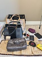 Overview of handbags, toiletry bag, organizer, accessories spread on floor