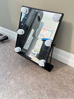 Front view of mirror showing six LED bulbs and stand
