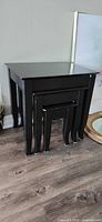 Front view of stacked black nesting tables