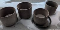 Four terracotta planters and drain saucer on balcony