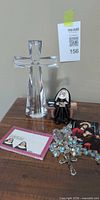 Overall lot showing crystal cross, rosary, nun figurine, prayer cards