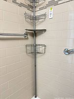 Full view of corner shower organizer showing three wire baskets, one metal tray, and tension pole