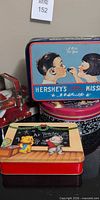 Group shot showing Hershey’s tin, teacher tin and Christmas tin