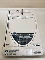 Front of unopened Kohler elongated bowl seat box