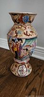 Full view of porcelain vase with painted Chinese figures and floral motifs
