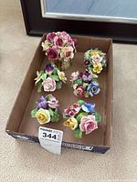 Group shot of six porcelain floral figurines in box