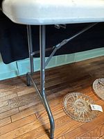 Side view of table showing plastic top and metal legs