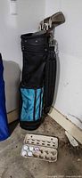 Golf bag standing with irons visible and egg carton holding balls