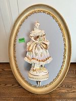 Front view showing entire oval frame and mounted porcelain figurine
